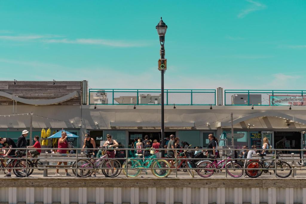 Asbury Park boardwalk scene with people and bikes on a sunny day