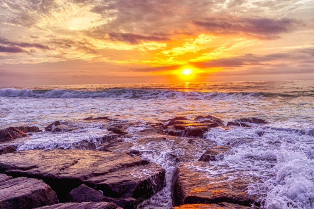 Asbury Park in summer. Waves crashing over the rocks.